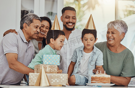 生日、庆祝活动和双胞胎在与家人的聚会上吹蛋糕上的蜡烛。