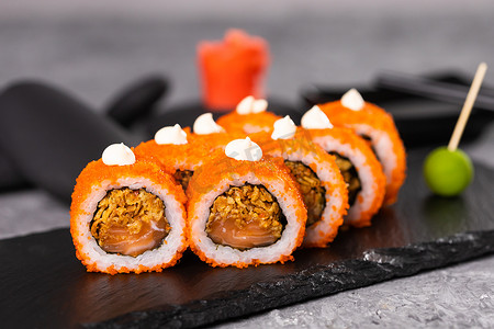大豆食品摄影照片_在深色背景上的寿司卷。