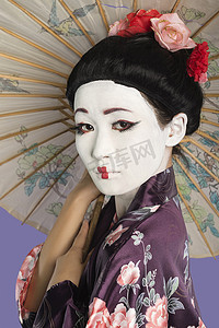 紫色背景下画着脸拿着阳伞的日本女人的特写