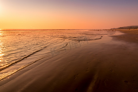 海边色彩缤纷的日落或日出，沙滩上有沙滩
