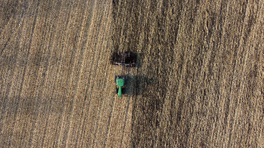 秋日空中收割小麦后拖拉机犁地黄田