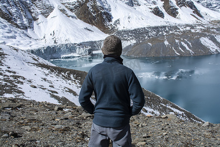男人站着看雪山湖景