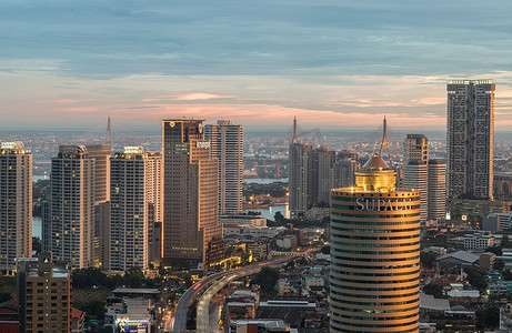 各种灯光摄影照片_曼谷市各种摩天大楼闪烁着明亮灯光的傍晚时间场景。