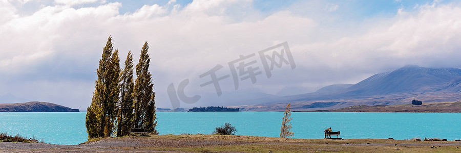 美丽的冬天二摄影照片_情侣在长凳上看着美丽的蓝色水湖