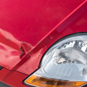 红色汽车前面的划痕和生锈的凹痕