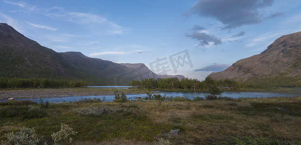 广阔的拉普兰全景自然景观，野生 Tjaktjajakka 河和 Kaitumjaure 湖与小桦树林岛和山脉交汇。