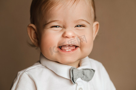 一个穿着白衬衫、打领结的快乐小男孩的肖像