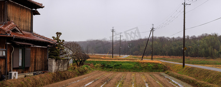小下雨天摄影照片_阴天小稻田和乡村道路旁的日本老木屋