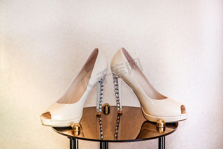 婚背景摄影照片_高跟鞋的婚鞋站在镜桌上，上面装饰着宝石