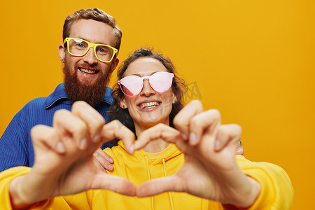 男女情侣欢快地微笑着，戴着眼镜，在黄色背景上，符号标志和手势，家庭拍摄，新婚夫妇。