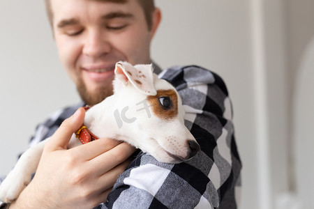 飞屋环游记罗素摄影照片_人与宠物的概念 — 杰克罗素梗小狗坐在男人手上的特写