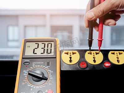 用数字表测量电源插座的 230 伏交流电压。