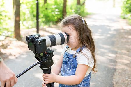 爱好、职业、儿童和摄影师的概念 — 森林里带相机的孩子