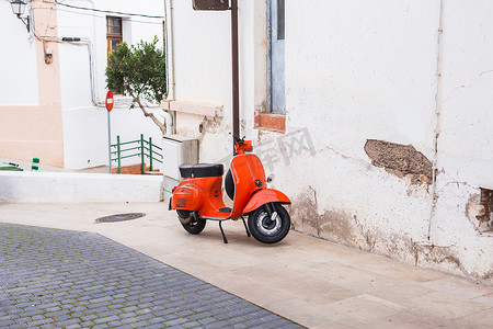vespa摄影照片_橙色摩托车 Vespa 停在西班牙巴塞罗那老街上
