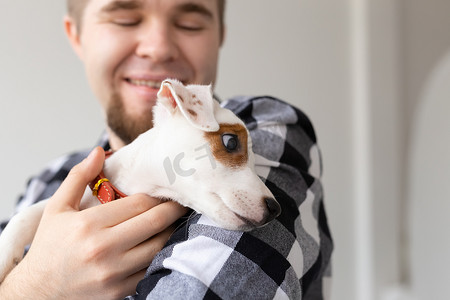 人、宠物和动物的概念 — 年轻人在白色背景下拥抱杰克罗素梗犬的特写