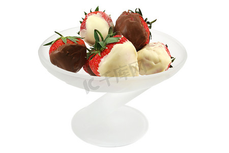 将白巧克力和牛奶巧克力浸在玻璃碗中的草莓