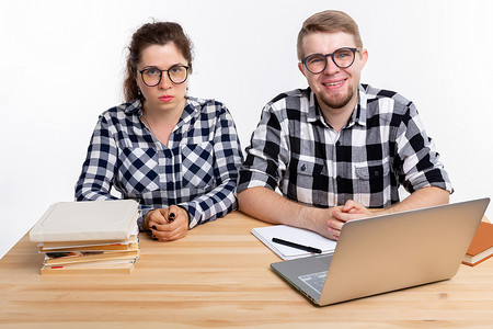 人与教育理念 — 两名身穿格子衬衫的学生坐在桌旁