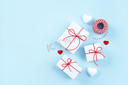 情人节、母亲节艺术设计理念 — 红色、白色包装礼盒隔离在柔和的淡蓝色背景、平躺、顶视图上。