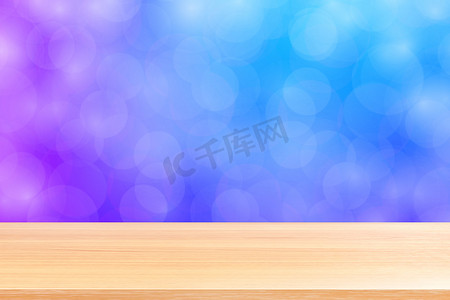 空木桌地板在模糊的散景柔和紫色渐变背景上，木板空在紫色散景彩色光罩上，彩色散景灯渐变软，用于横幅广告产品