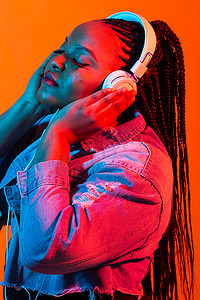 年轻的非洲女人戴着耳机听音乐的霓虹画像。