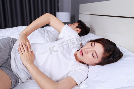 女人和丈夫在床上胃痛