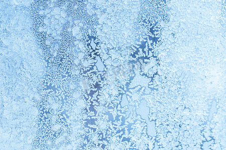 冬天窗户背景摄影照片_在寒冷的天气里，玻璃的质地在冬天覆盖着霜。