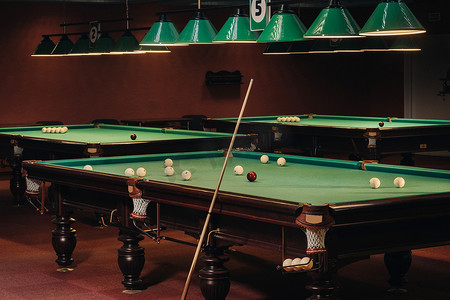 国潮台球摄影照片_台球俱乐部里有绿色表面和球的台球桌。台球比赛