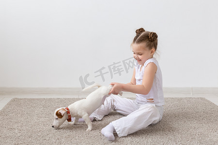 儿童动物背景摄影照片_宠物、儿童和动物概念 — 小女孩用爪子抱着小狗