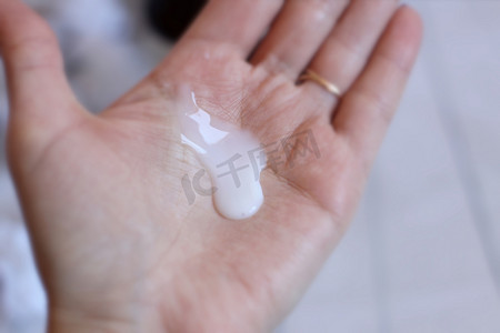 手中的泡沫摄影照片_女性手中的奶油洗发水。