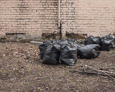 花园里堆垃圾塑料袋，垃圾袋废物造成的污染，垃圾袋塑料堆，垃圾袋塑料黑很多，堆垃圾袋