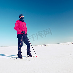 穿着雪鞋的冬季游客在雪地里行走。