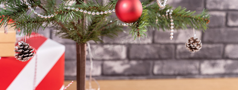 装饰圣诞树，在家里用黑色砖墙包裹着漂亮的红白相间的礼物，喜庆的设计理念，特写