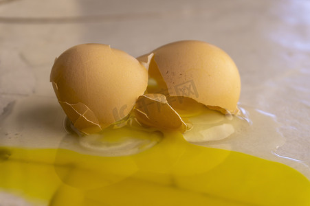 砸蛋摄影照片_分裂黄色轭和一个破蛋的白色