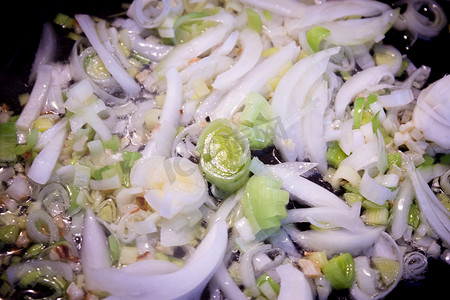 洋葱与韭菜一起在煎锅中翻炒