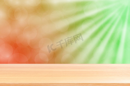 空木桌地板在柔和的绿色散景灯光束闪耀渐变背景，木板空在绿色散景多彩光闪耀，彩色散景灯渐变柔和用于横幅广告