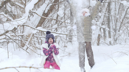 两个小女孩在冬季森林里玩雪。