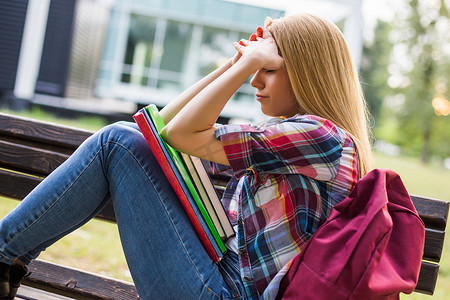 女性疲惫摄影照片_精疲力尽和担心的女学生学习