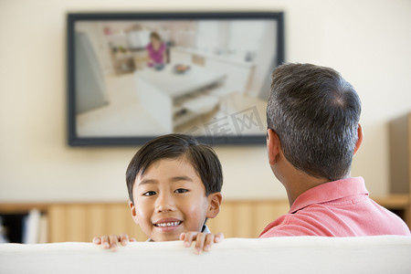 男人和小男孩在客厅里配有平面电视 smi