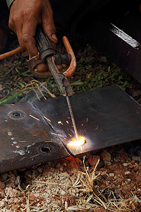 电焊工人摄影照片_工人使用电焊