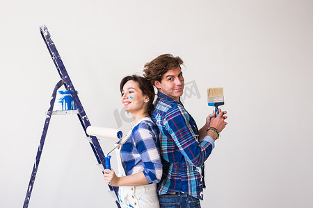 团队合作、维修和翻新概念 — 新公寓里被油漆覆盖的男人和女人