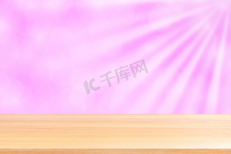 空木桌地板上柔和的粉红色散景灯光束闪耀渐变背景，木板空在粉红色散景彩色灯光照耀下，粉红色彩色散景灯渐变柔和，用于横幅广告