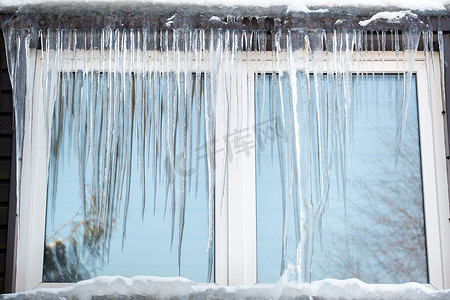 农村大窗户摄影照片_在寒冷的日子里，房子窗户上的冰柱。