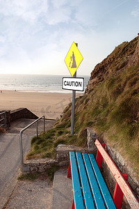 泥石流标志摄影照片_长凳和海滩山体滑坡警告标志