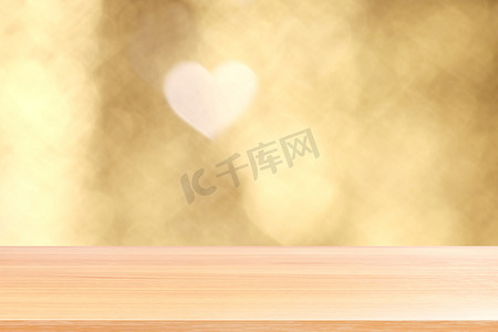 漂亮的桌面背景摄影照片_散景灯上的木板心形软金色背景情人节，空木桌地板上的心形灯形状背景五颜六色的金色，木桌板上空的散景心形金色