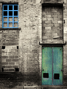 废弃厂房摄影照片_带有蓝色窗户和绿色门的废弃工业仓库和厂房的复古风格彩色图像