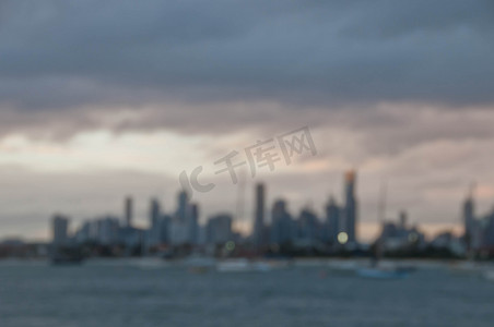 澳大利亚墨尔本的摩天大楼地平线与海洋和高大的办公楼和住宅楼模糊抽象的夜景