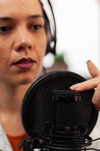 博客女性在家庭工作室中使用专业录音技术在播客中谈论生活方式