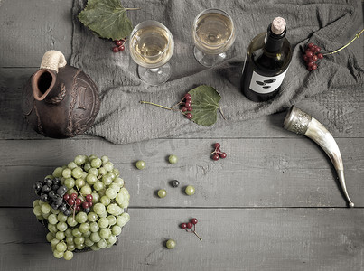 红色小五角星摄影照片_一瓶葡萄酒、葡萄和葡萄酒，装在水壶和玻璃杯中。