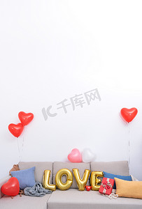 情人节，母亲节惊喜设计理念，将爱情气球和礼物放在背景为白墙的沙发上。