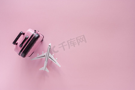 白色飞机模型，粉红色背景中带小行李
